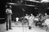 Etheridge Knight: Oxford, Miss. Knight performing at microphone in front of small audience (EKP 2-79-12/11 #295)