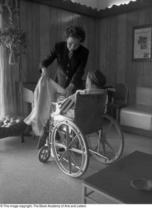 Tiny Hawkins helping a woman in a wheel chair