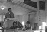 Norman Lumpkin speaking to an audience in a small wooden church building in Prattville, Alabama, probably during a meeting of the Autauga County Voters Association.