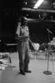 Etheridge Knight: Oxford, Miss. Knight performing at microphone in front of small audience (EKP 2-79-12/11 #295)