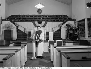 Photograph of Dr. S. M. Wright standing in a church's nave #2