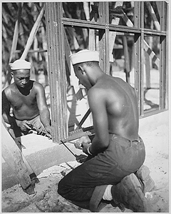 "Construction of the prefabricated steel storage warehouse [by members of the 34th Construction Bn.] at Halavo Seaplane Base, Florida Island [Solomon Islands]."