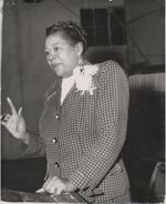 Mississippi State Sovereignty Commission photograph of Lillian S. Moore standing and wearing a corsage, Magnolia, Mississippi, 1950s