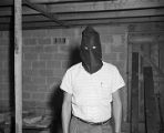 Man posing in a Ku Klux Klan hood that was confiscated after the arrest of members in Jefferson County, Alabama.