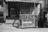 Sidewalk sign advertising The Black Press, a printing business in Harlem.