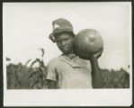 African-American girl with watermelon on shoulder, near Manning