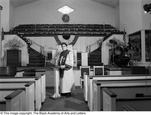 Photograph of Dr. S. M. Wright standing in a church's nave