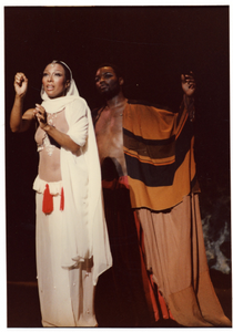 Performance photo of a man and a woman, the woman is wearing a white robe]. [color photoprint