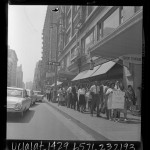 Protest march down sidewalk, sign reading "NAPP For Community Action" in downtown Los Angeles, Calif., 1966