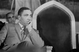 Joseph Lowery sitting behind the podium, listening to Martin Luther King, Jr., speak during a meeting at St. Paul AME Church in Birmingham, Alabama.