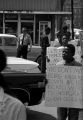 Protestors carrying signs while marching past businesses in downtown Prattville, Alabama, during a civil rights demonstration.