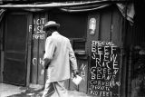 Jasper Wood Collection: Man in suit walking by neighborhood eatery