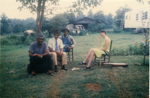 Charlie Hill, two unidentified men, and Marjorie Merrill (l. to r.) seated on a lawn