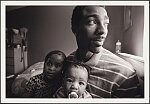 From "Father Figure: Exploring Alternate Notions of Black Fatherhood." Guy Miller relaxes in his bedroom with oldest daughter, Nijeyah, and newborn son Guy "Chum" Jr., Bronx, New York