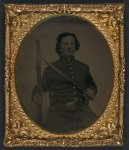 [Unidentified soldier in Union frock coat and SNY (State of New York) belt buckle with musket, sword bayonet, and revolver]