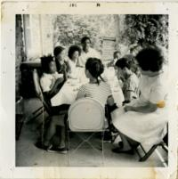 Children and Adults Eating at a Table on a Porch