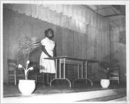 Woman Standing Behind Table