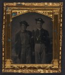 [Two unidentified soldiers in Union uniforms and slouch hats in front of painted backdrop]