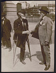 [Civil War veterans William H. Calvert of Co. C, 77th Pennsylvania Infantry Regiment, with ladder badge and crutches, and William G. DeLashmutt of Co. D, 1st Maryland Cavalry Battalion, with United Confederate Veterans medal shaking hands at the 1913 Gettysburg reunion]