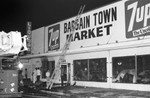 Firemen surveying Bargain Town Market fire damage, Los Angeles, 1971