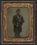 [Unidentified young soldier in Union frock coat and forage cap with bayonet scabbard, cartridge pouch, ammunition box, and bayoneted musket]