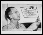 Noble Bradford, lead man in Dallas Transit Co. body shop, removes seperate [i.e. separate] seating sign from rear of bus after the company announced it was ending passenger segregation on its 530 busses at once