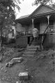 Woman climbing steps of slum house.