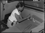 Worker cleaning ashtrays in Zephyr coach, 14th Street passenger yards, Chicago, May 1948