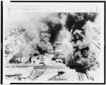 Three buildings burn on Avalon Blvd. and a surplus store burns at right as a looting, burning mob ruled the Watts section of Los Angeles