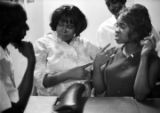 Tom Catledge talking with two women at Tom's Place at 648 South Holt Street in Montgomery, Alabama.