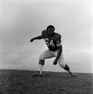 NTSU football player squatting with fists, 15