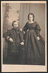 [Acting Volunteer Lieutenant David Cate of U.S. Navy and his second wife, Ellen T. Chase Cate, in front of painted backdrop showing wall and landscape]