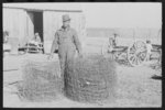 Negro sharecropper with wire which he has rolled up after taking down fences on his rented farm, Transylvania Project, Louisiana