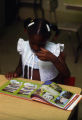 Girl looking at book with illustrations of plants