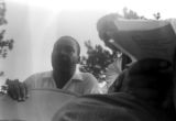 Whitney M. Young, Jr., speaking to Martin Luther King, Jr., while seated on a platform in front of the state capitol in Jackson, Mississippi, at the end of the "March Against Fear" begun by James Meredith.