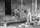 John Nixon trying to climb onto the porch of his house in Autaugaville, Alabama.