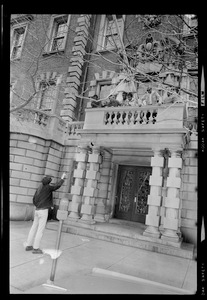 Sympathizer points to Black students on small balcony over entrance to Administration Building at Boston University