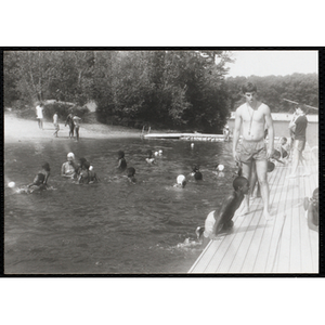 Thumbnail for A swimming supervisor watches two boys on a dock