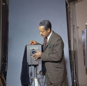 Robert Scurlock adjusting shutter of large-format view camera in studio : acetate color photonegative.