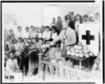 Typical colored school near Shaw, Mississippi. It is held in a church. The teacher is distributing fruit sent to the Red Cross from Lake Wales, Florida