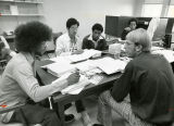 College of Business Administration students work on their homework seated around a seminar table, circa 1975