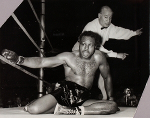 Unidentified boxer, seated in ring, with referee