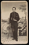 [3rd Assistant Engineer Cipriano Andrade of U.S. Navy in uniform in front of painted backdrop showing balustrade and courtyard]