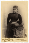 Thumbnail for Portrait of woman in black dress leaning on chair