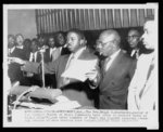 [Reverend Ralph D. Abernathy attempting to calm the audience at the First Baptist Church following a standing ovation for leaders of the bus boycott]