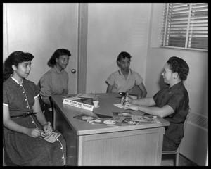 Four Women Sit at a Desk