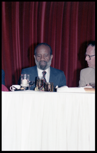 Lerone Bennett, seated at the table of honor for James Baldwin's 60th birthday celebration, UMass Campus Center