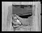 Child of Negro sharecropper looking out window of cabin home. There is a great deal of malaria in this section bad and no screening being a contributing cause. Near Marshall, Texas