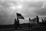 Man carrying an American flag during the 20th anniversary reenactment of the Selma to Montgomery March.