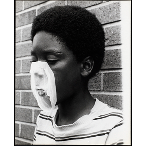 An African American boy from the Roxbury Boys' Club popping a bubble gum bubble